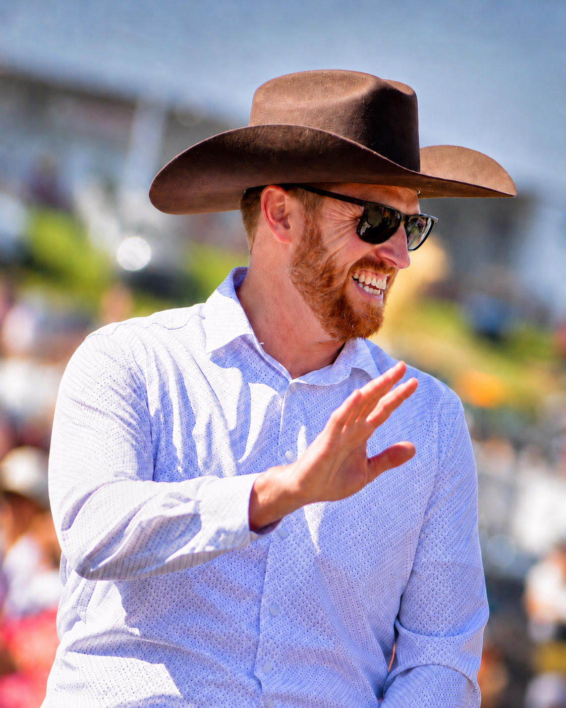 Dusty Myshrall smiling and waving during a community parade